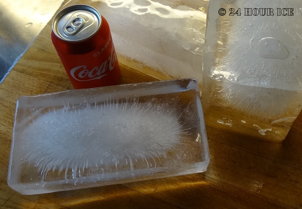 Three ice bricks next to a coke can.
